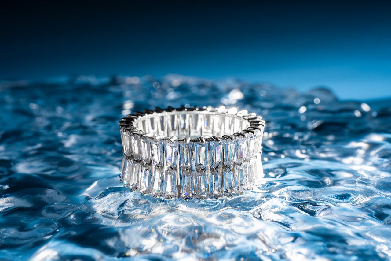 A stunning silver diamond ring elegantly displayed on a reflective ice-textured surface, showcasing luxury and elegance.