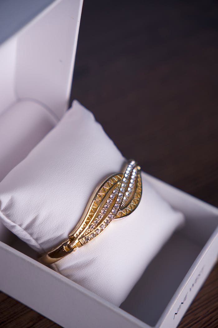 A stunning gold bracelet with diamonds elegantly presented in a white gift box, perfect for special occasions.
